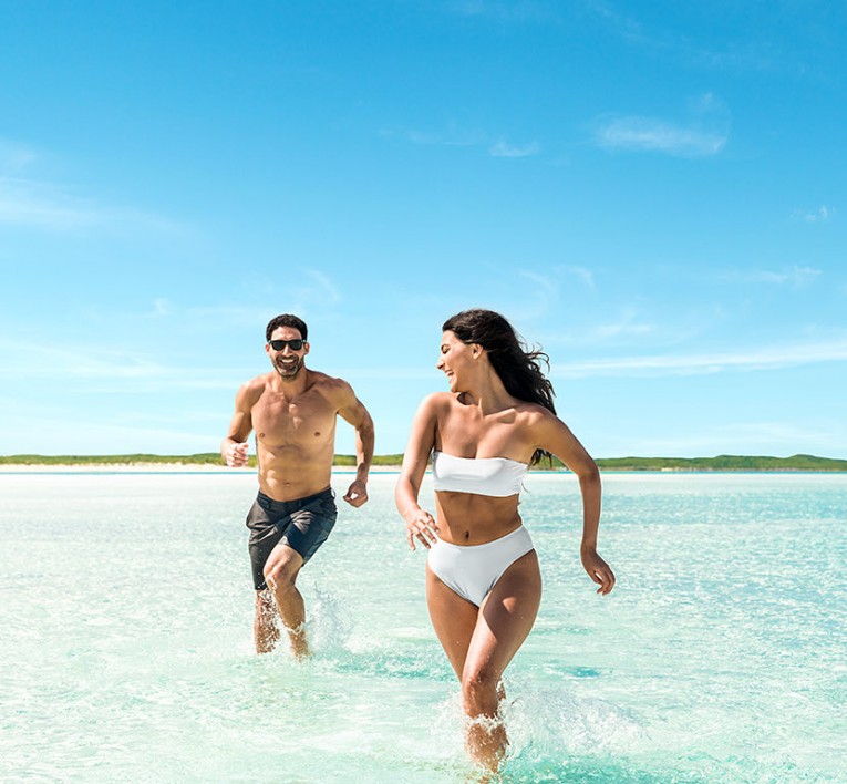 couple running in the water on the beach