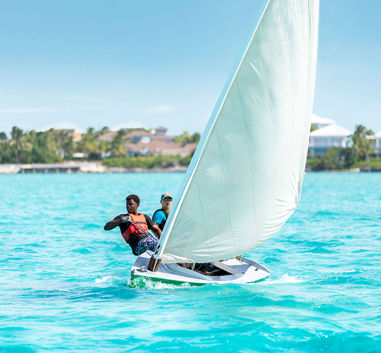 a couple of people on a sailboat in the water