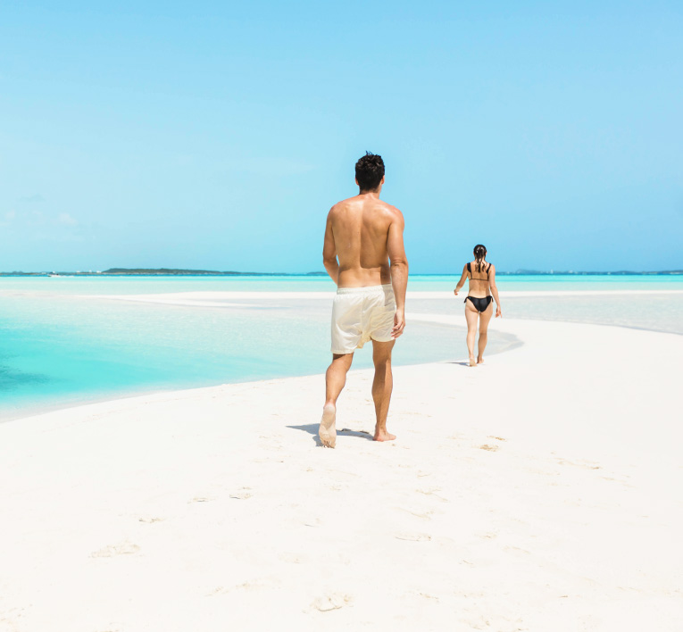 a man and woman walking on a beach