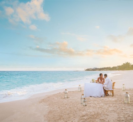 a couple sitting at a table on a beach