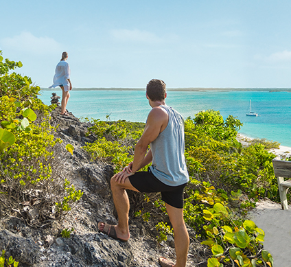 man and women hiking looking out to the ocean   424x389px