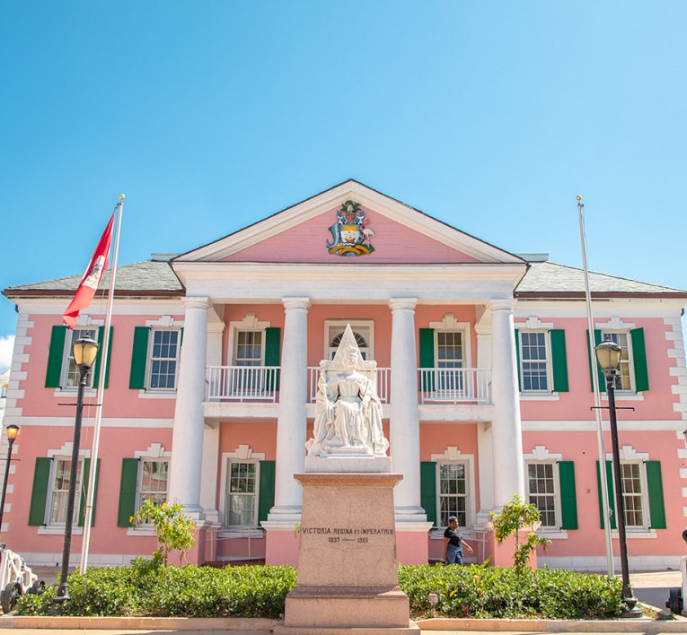 a pink building with tall white columns 