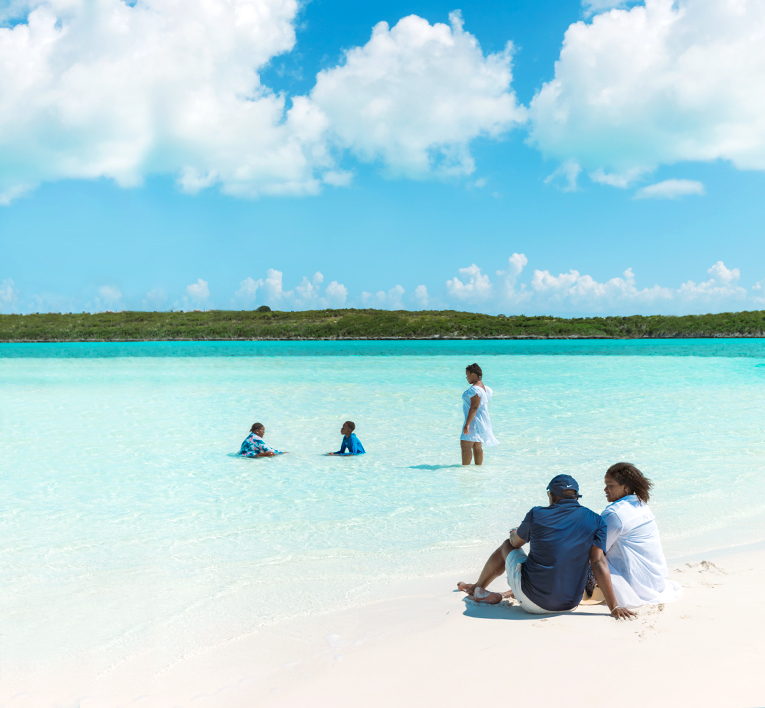 a family sitting on the beach