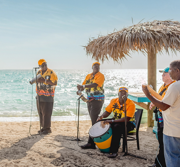 a group of men playing music on a beach