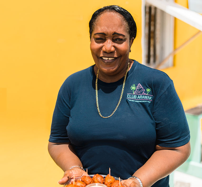 a woman smiling and holding a plate of food